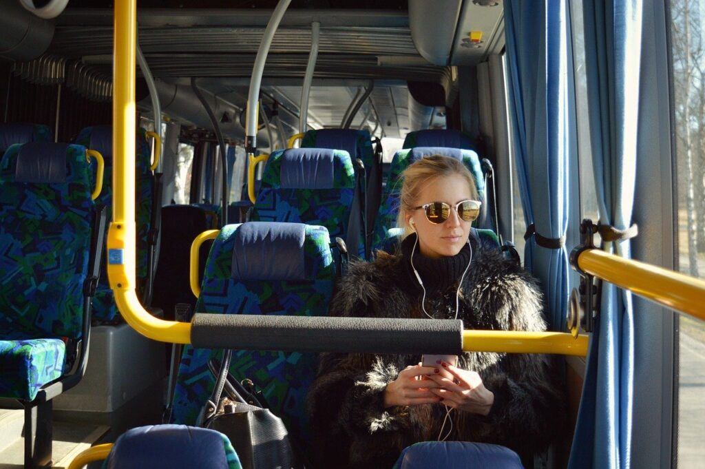 サングラスをかけてバスの中から外をみる女性