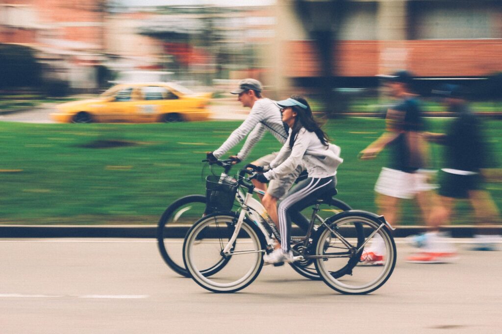 街中をシティサイクルで走る男女