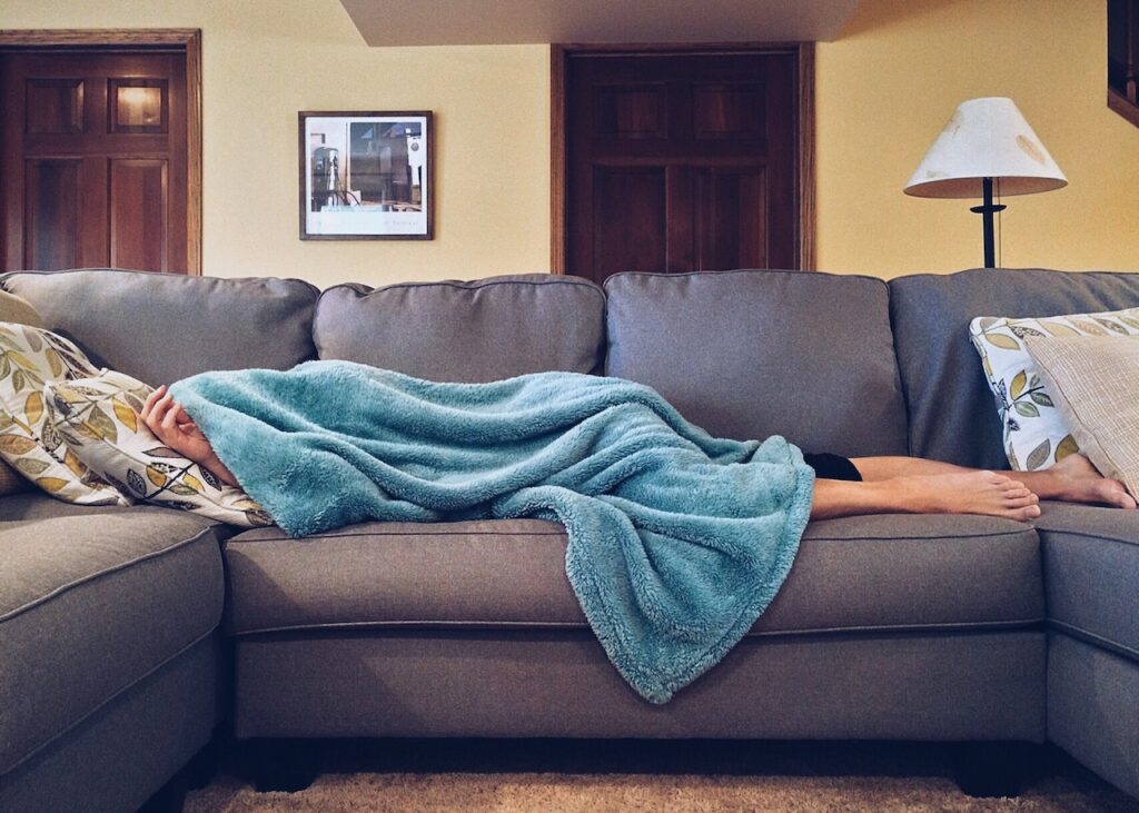 ソファに毛布で寝ている人